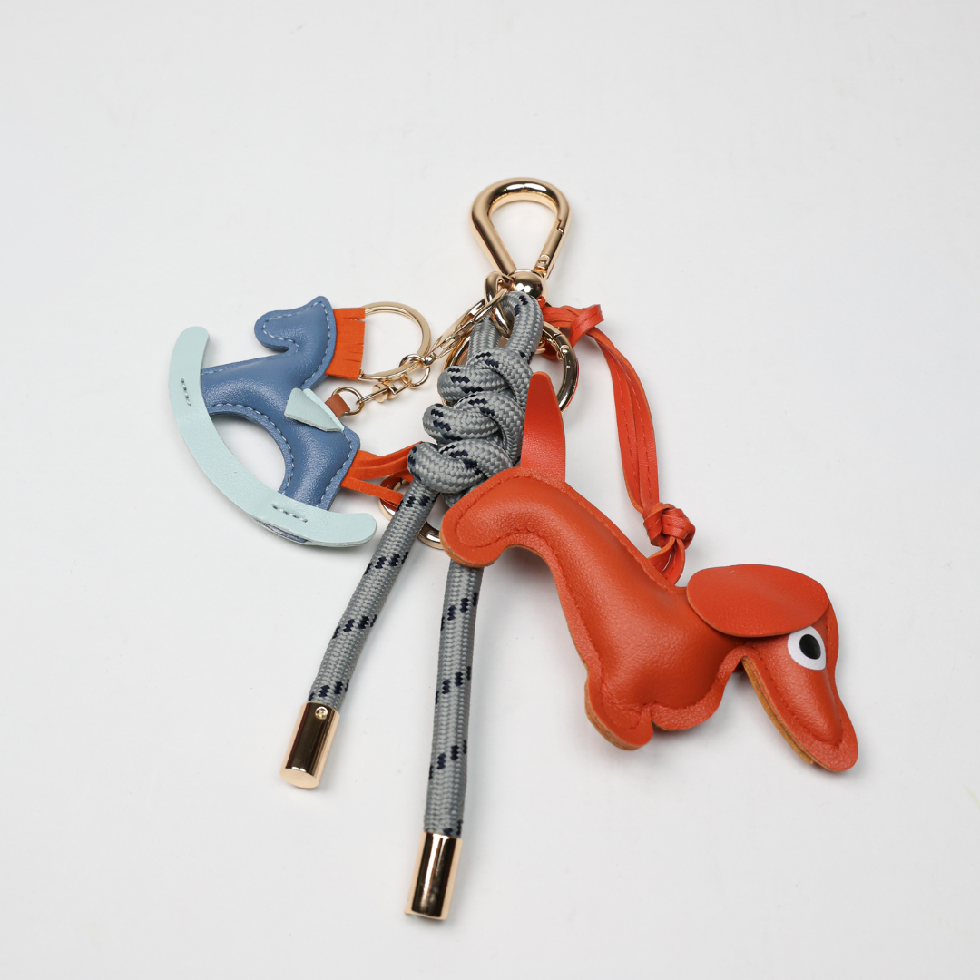 KEY CHAIN STONE GREY WITH CHARMS - ORANGE DOG AND BLUE ROCKING HORSE